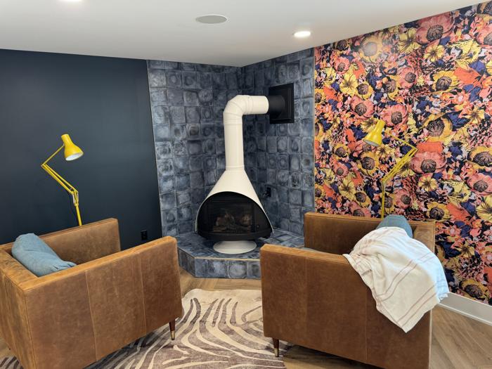 Bold floral feature wall by a mid-century fireplace