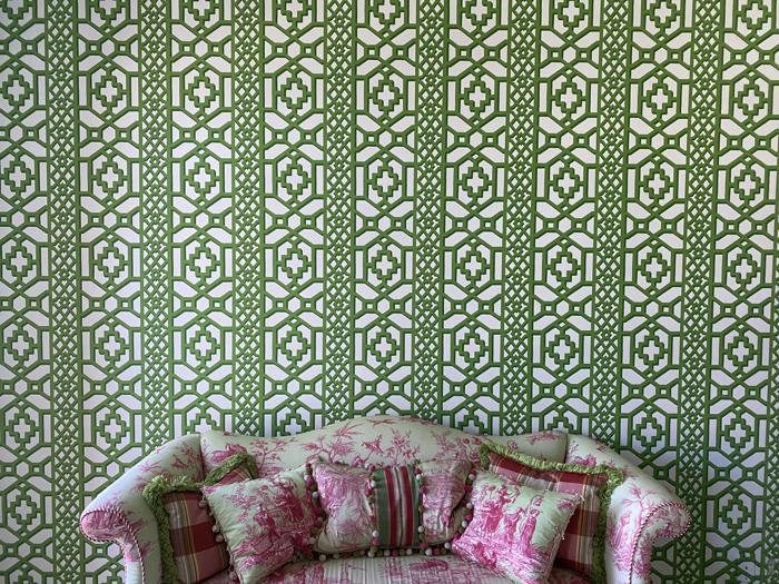 Green trellis wall behind a floral settee