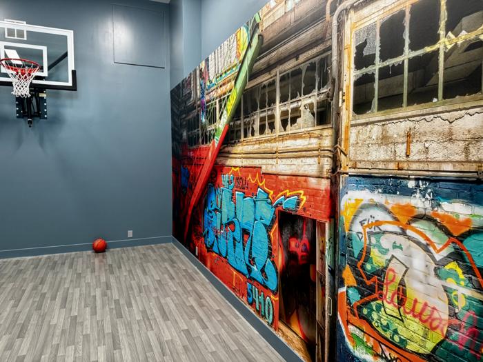 Graffiti train mural in a home sports court