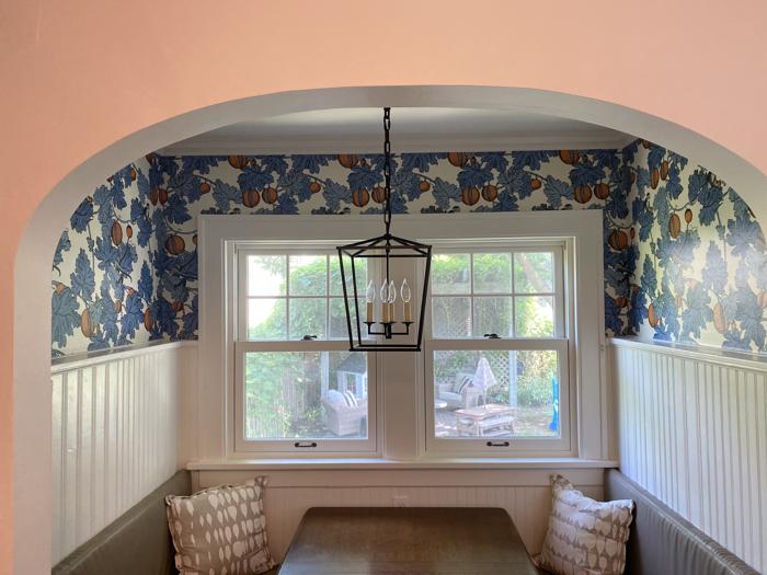 Breakfast nook under an arch with blue botanical paper