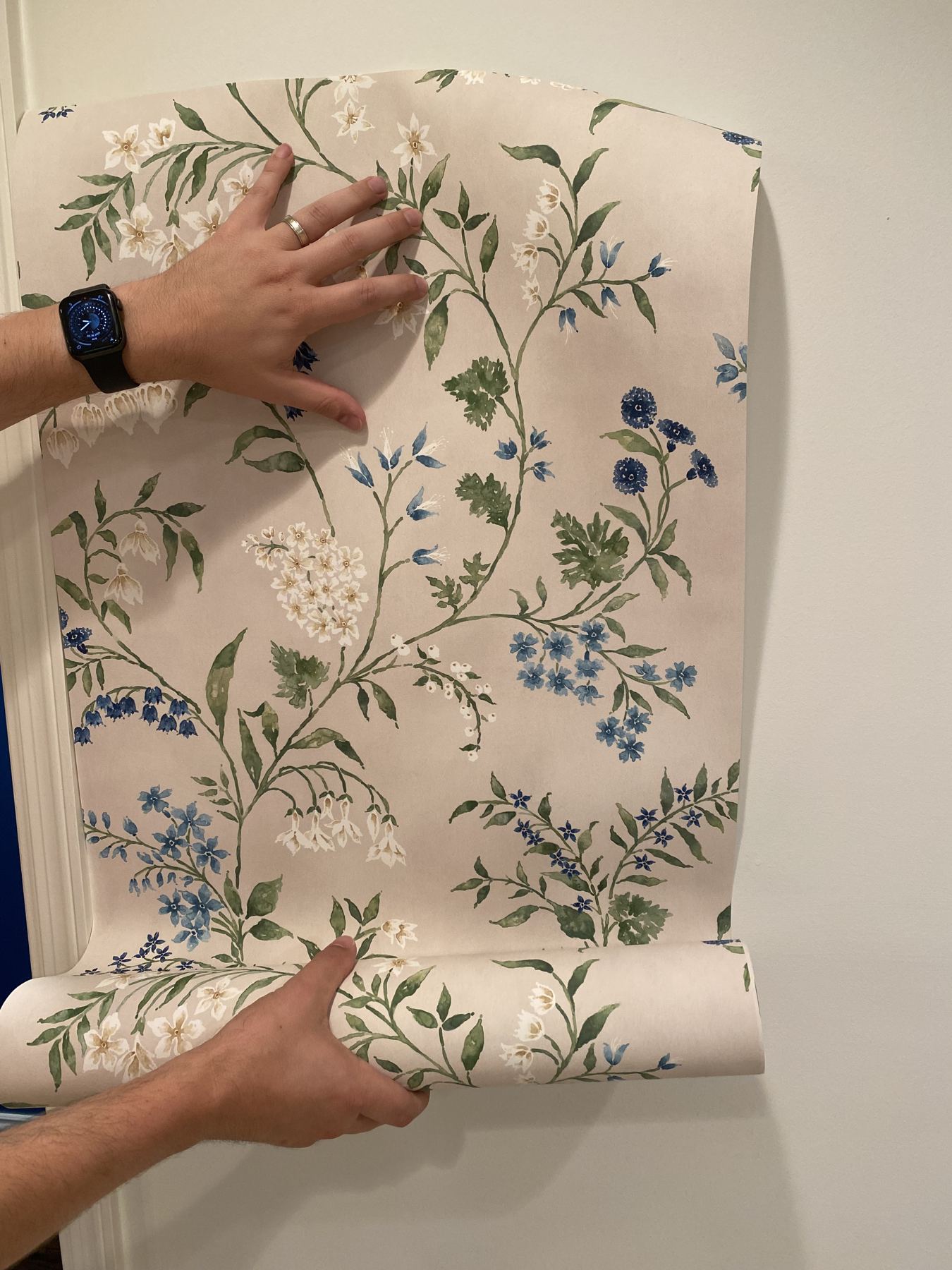 Holding up a floral wallpaper panel